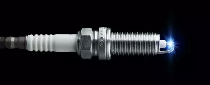 What is a spark plug and what does it do?