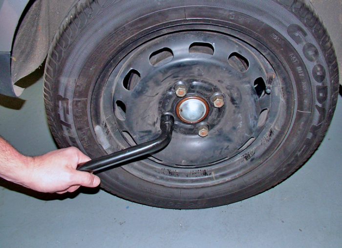 Loosen (but don't remove) the nuts or bolts with the wheel brace