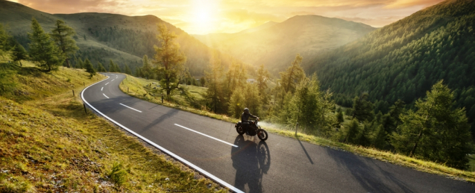 Motorcycle and rider cruise a mountain pass