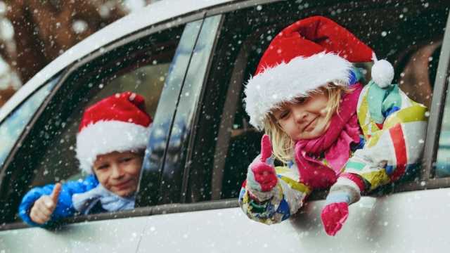 Kids in Christmas Hats in snowy car