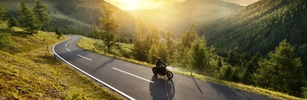 Motorcycle and rider cruise a mountain pass