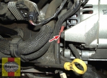 On V6 models, also remove the bracket bolt (if equipped) at the rear of the alternator (arrow)