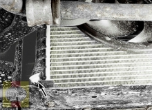 The drain fitting is located at the lower corner of the radiator