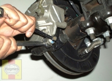 1500 hold the caliper slide pin and loosen the lower mounting bolt, pivot the caliper up